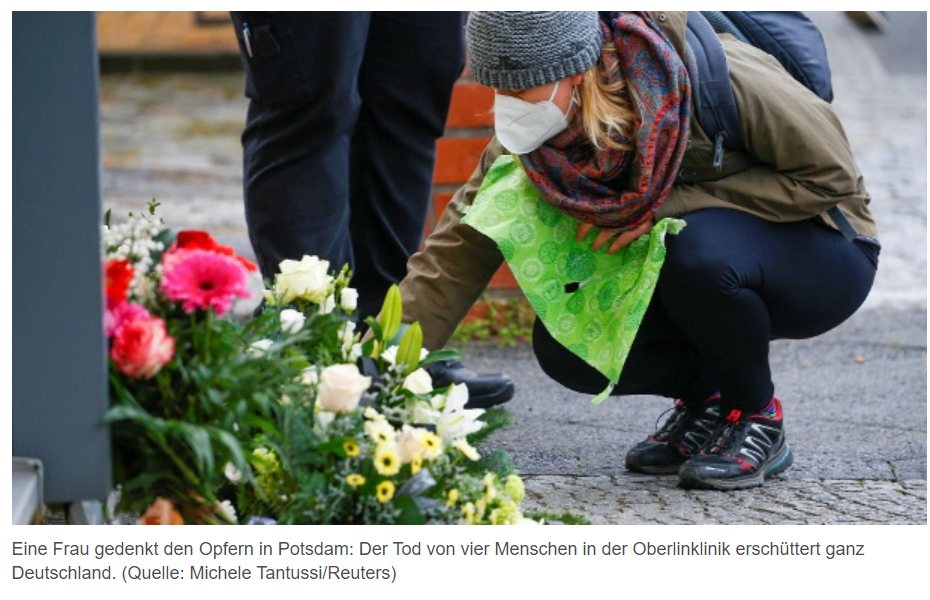 Eine Frau legt an einer Gedenkstätte Blumen nieder