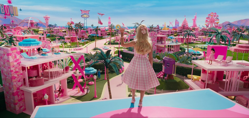 Eine blonde Frau mit pinkem Kleid schaut auf eine Pinke Stadt.