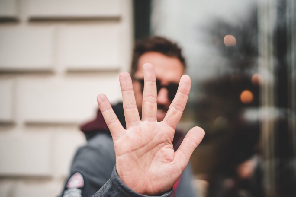 Eine Person hält seine ausgestreckte Hand in Richtung Kamera.