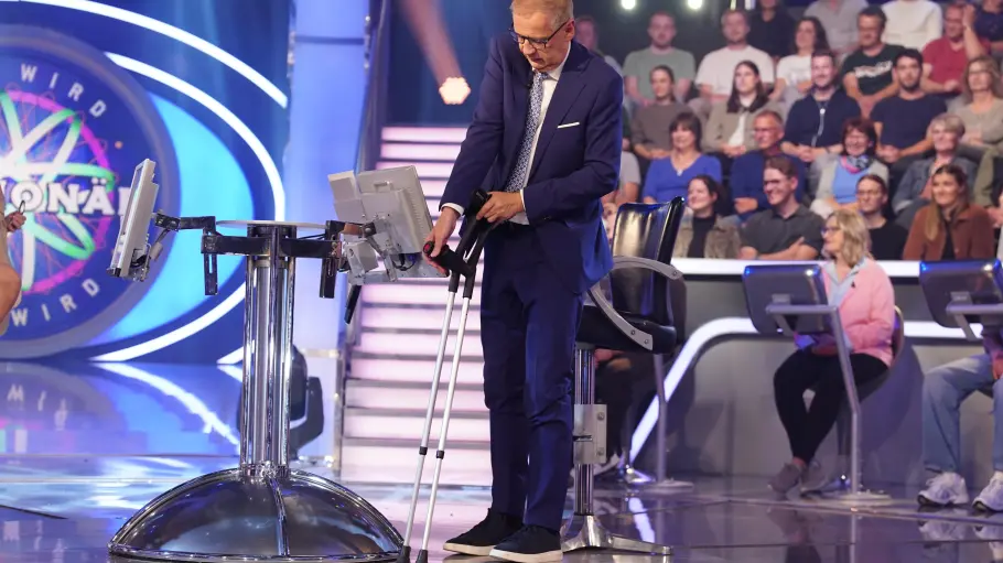 Günter Jauch ist im „Wer wird Millionär“-Studio und hält Krücken in der Hand.