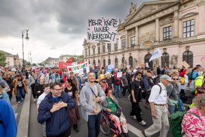 Demo am 5. Mai in Berlin zum Europäischen Protesstag für die Gleichstellung von Menschen mit Behinderungen. Eine Person trägt ein Plakat mit der Aufschrift: Mehr Knete inner Werkstatt.