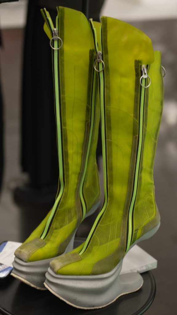 Designerschuhe neongelb mit mehreren Reißverschlüssen und einem weißen Absatz.