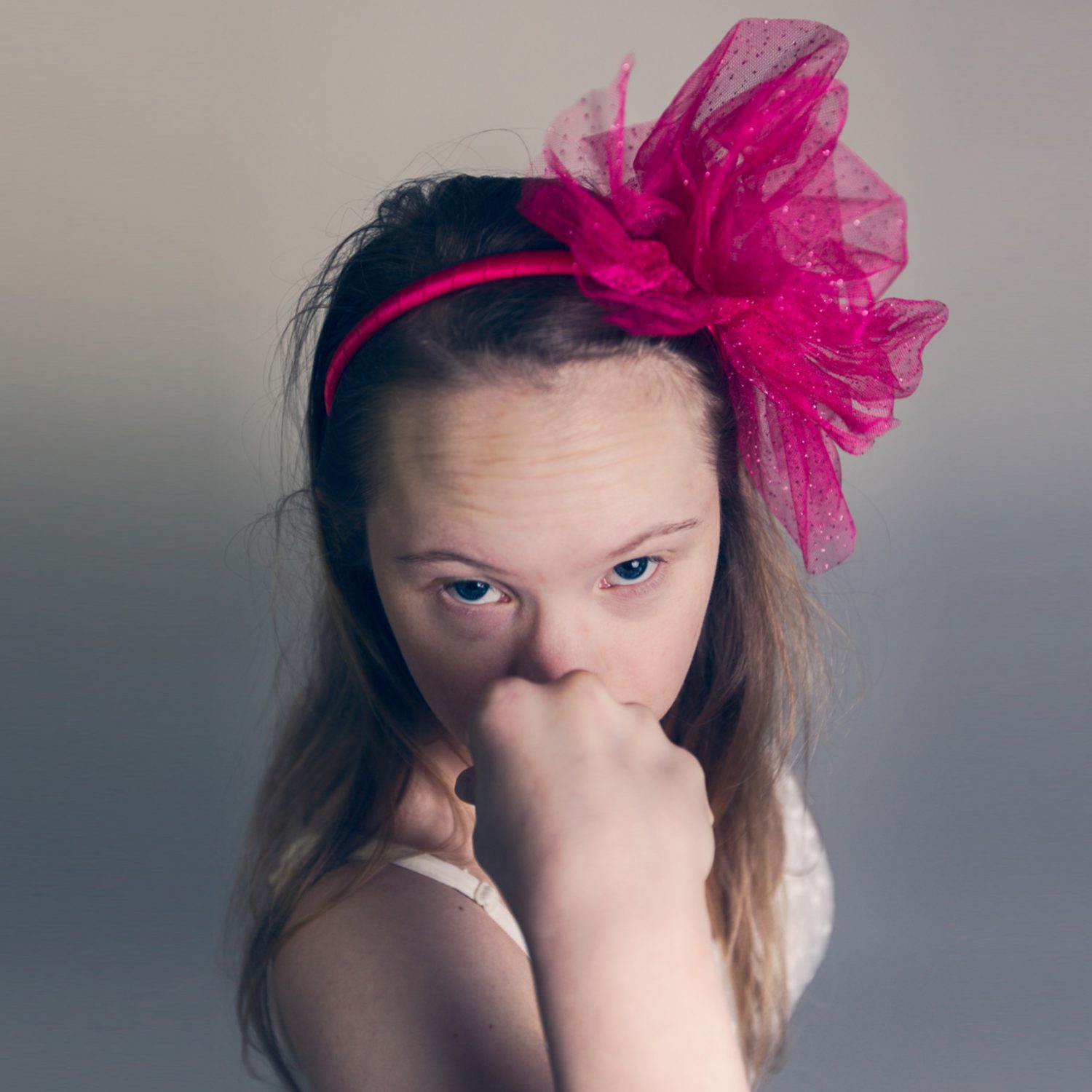 Eine Tänzerin mit Downsyndrom hebt ihre Faust der Kamera entgegen